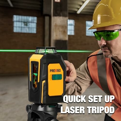 Worker setting up a laser level tool on a tripod.